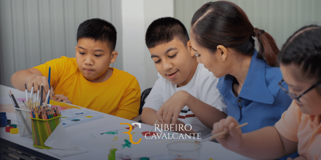 Crianças e professora participando de atividades de pintura na aula. Imagem com logo ribeiro cavalcante advocacia.