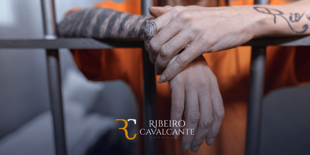 Mãos tatuadas segurando barras de prisão com logo da ribeiro cavalcante advocacia. Especialistas em direito previdenciário.