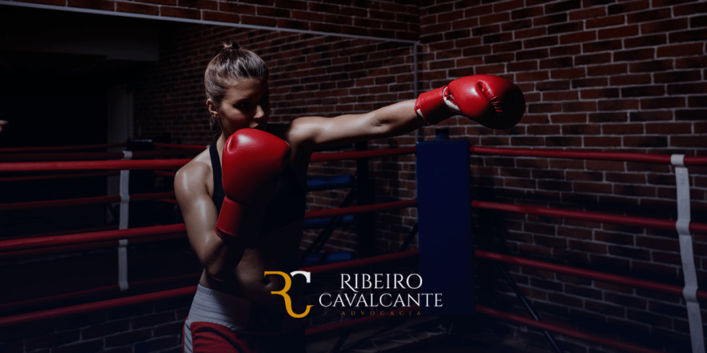 Mulher boxeadora treinando no ringue com luvas vermelhas, logotipo da ribeiro cavalcante advocacia ao redor.