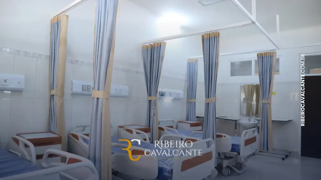 Interior de hospital com camas e cortinas azuis